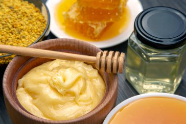 Farklı çeşitlerde taze çiçek balı, polen ve ahşap arka planda kaşıkları olan bal peteği. Organik Vitamin Sağlıklı Gıda