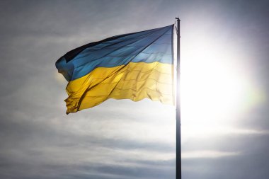 Ukrayna 'nın ulusal bayrağı güneş ve mavi gökyüzünün arka planına karşı. Vatanseverlik ve ulusal sembol