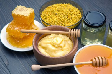 Farklı çeşitlerde taze çiçek balı, polen ve ahşap arka planda kaşıkları olan bal peteği. Organik Vitamin Sağlıklı Gıda