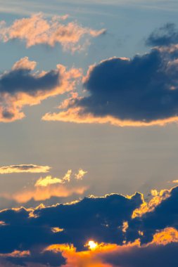 Gün batımında bulutlu gökyüzü ile çelişiyor.