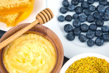 Tahta arka planda taze bal, fındık, çilek ve yaban mersini. sağlıklı organik vitamin yiyeceği.