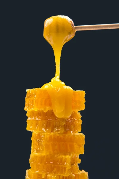 Fresh viscous flower honey falls down from a wooden spoon. vitamin organic food