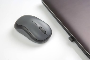 Beyaz bir masadaki dizüstü bilgisayarın yanında kablosuz fare. elektronik kişisel endüstri