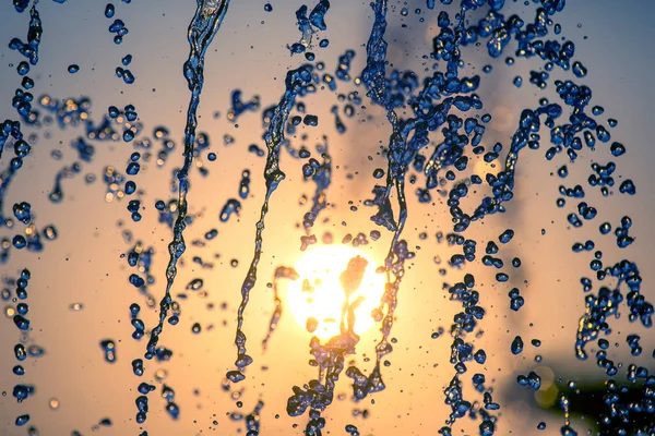 Silhuetter Droppar Fallande Vatten Fontän Mot Bakgrund Nedgående Sol — Stockfoto