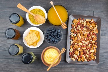 Tahta arka planda taze bal, fındık, çilek ve yaban mersini. sağlıklı organik vitamin yiyeceği.