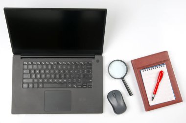 Laptop, büyüteç, bilgisayar faresi, akıllı telefon, kalem, beyaz arka planda not defteri. İş ve mal satın almak için internet üzerinden eşyalar
