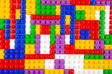 Renkli yapı bloklarının soyut arkaplan dokusu. İnşaatçının renkli plastik parçalarının arka planı. Renkli oyuncak yığınları..