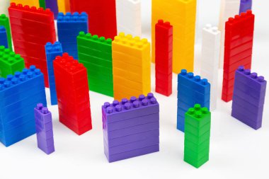 çok katlı binalar şeklinde beyaz bir zemin üzerinde bir plastik yapıcının renkli blokları. Modern binalar ve evler kavramı