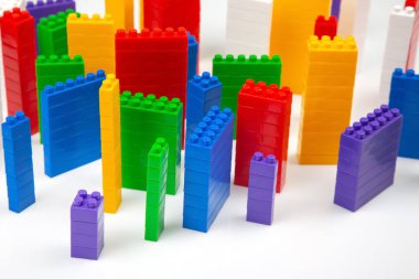çok katlı binalar şeklinde beyaz bir zemin üzerinde bir plastik yapıcının renkli blokları. Modern binalar ve evler kavramı
