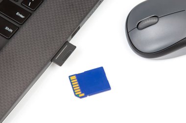 SD hafıza kartı beyaz arka planda bir dizüstü bilgisayarın yanında elektronik veri kaydetmek için. elektronik sanayi ve bilgi ögeleri