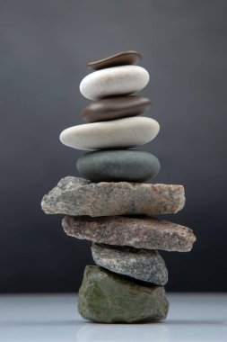 Karanlık bir arka planda istiflenmiş taş piramidi. Hayatta dengeleme ve denge