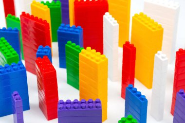 çok katlı binalar şeklinde beyaz bir zemin üzerinde bir plastik yapıcının renkli blokları. Modern binalar ve evler kavramı