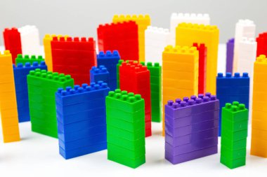 çok katlı binalar şeklinde beyaz bir zemin üzerinde bir plastik yapıcının renkli blokları. Modern binalar ve evler kavramı
