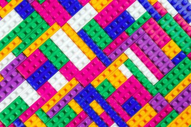 Renkli yapı bloklarının soyut arkaplan dokusu. İnşaatçının renkli plastik parçalarının arka planı. Renkli oyuncak yığınları..