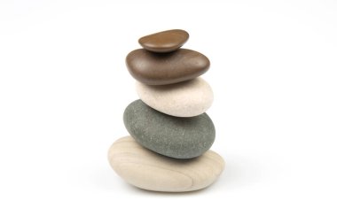 Beyaz zemin üzerinde istiflenmiş taşlar piramidi. Hayatta dengeleme ve denge