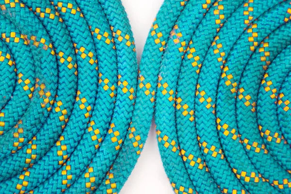 durable colored rope for climbing equipment on a white background. coil of braided cable. item for tourism and travel