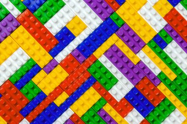 Renkli yapı bloklarının soyut arkaplan dokusu. İnşaatçının renkli plastik parçalarının arka planı. Renkli oyuncak yığınları..