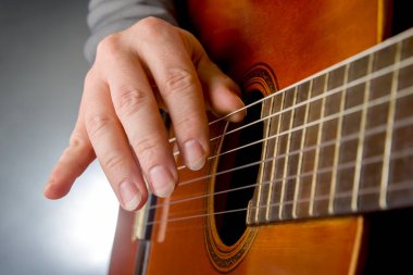 man plays the classical guitar. string musical instrument. hands of the musician playing on classical guitar