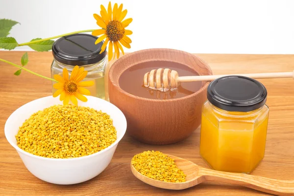 Fresh flower honey in a wooden bowl, spoon, pollen. vitamin food for health and life