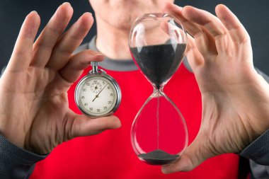 mechanical stopwatch and hourglass in hand. Time part precision. Measuring the speed interval with a watch