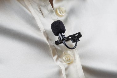 Ses kaydı için mandaldaki küçük mikrofon göğüsteki kadın gömleğine iliştirilmiş.