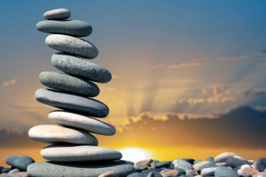 Günbatımının arka planına karşı pürüzsüz taş piramidi. Hayatın doğal dengesi.