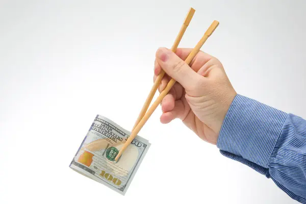 手は白い背景に竹箸でドルを持っています 食料品の金融業界です 現金支出の概念 — ストック写真