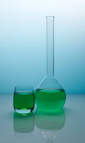 Πράσινο υγρό μέσα στο γυαλί Retort - Φωτογραφία με μπλε βαθμονομημένο φόντο — Φωτογραφία Αρχείου