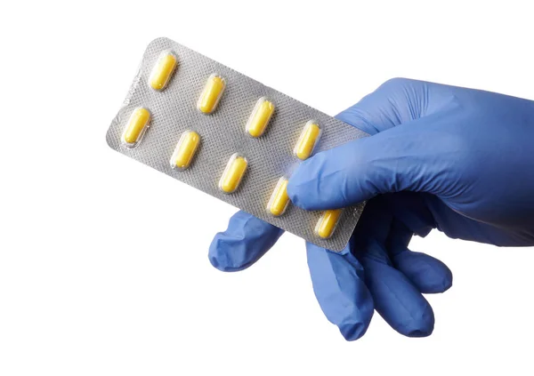 Gloved Hand Offers Blister of Yellow Pills - Isolated Photo — Stock Photo, Image