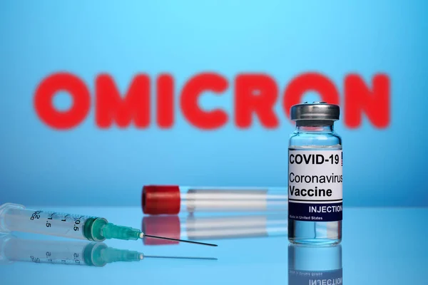 Vacuna y jeringa covid para la cepa de Omicron en un fondo de gradiente azul — Foto de Stock