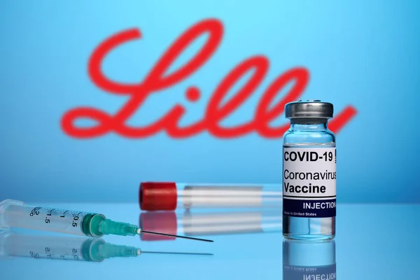 Vacuna y jeringa Eli Lilly Covid sobre fondo de gradiente azul —  Fotos de Stock