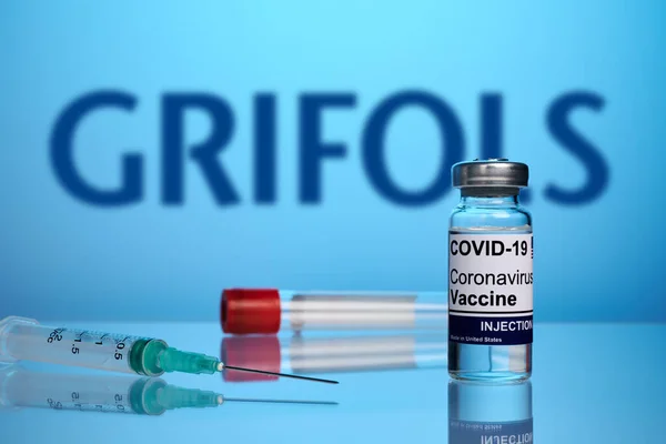 Vacuna y jeringa Grifols Covid sobre fondo de gradiente azul — Foto de Stock
