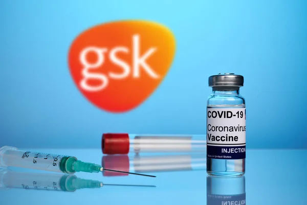 Vacuna y jeringa GSK Covid sobre fondo de gradiente azul —  Fotos de Stock