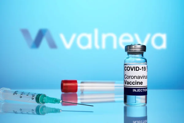 Vacuna y jeringa Valneva Covid sobre fondo de gradiente azul — Foto de Stock