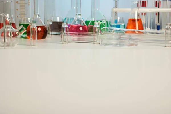 Vidros de laboratório na mesa branca com Copyspace — Fotografia de Stock