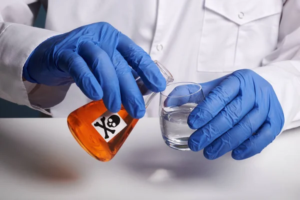 Доктор разливает оранжевый яд из фляжки - Лаборатория Фото — стоковое фото