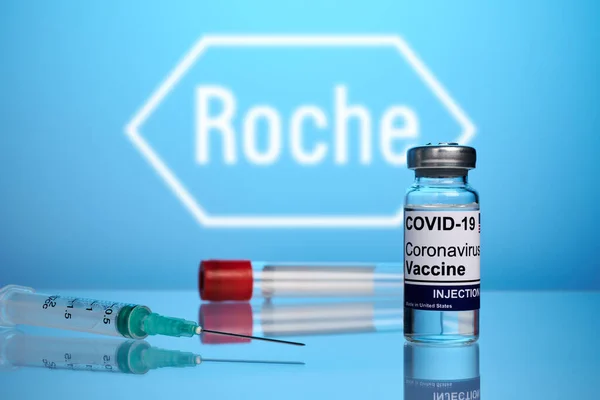 Vacuna y jeringa Roche Covid sobre fondo de gradiente azul — Foto de Stock