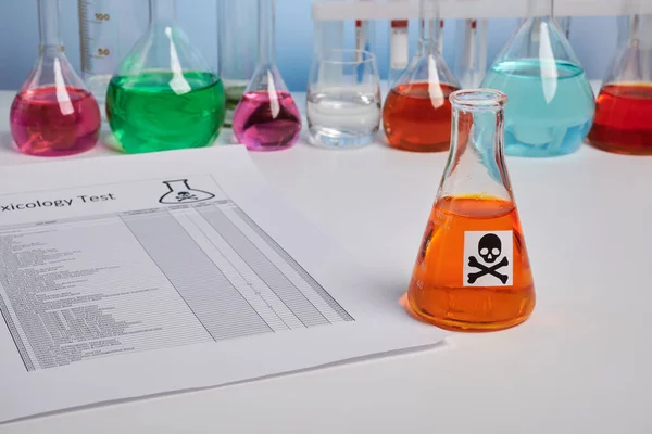 Giftig rapport voor sinaasappelsap en gekleurde chemische kolven — Stockfoto
