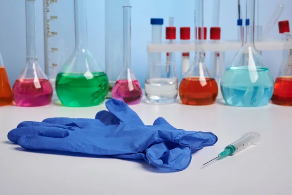 Rękawica i strzykawka na biurku chemicznym - zdjęcie laboratoryjne — Zdjęcie stockowe