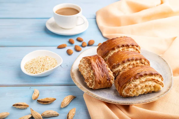 Geleneksel Ermeni tatlı gata mavi ahşap arka planda bir fincan kahve ve turuncu keten tekstil. Yan görünüm, kapat.