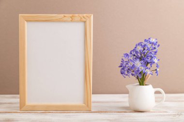 Bahar kardelenli ahşap çerçeve bej renkli pastel arka planda chionodox çiçekleri. Yan görünüm, kopyalama alanı, natürmort, model, şablon, bahar minimalizmi kavramı.