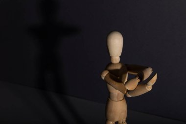 Wooden mannequin shows obscene gesture fuck off with hands on gray background. protest, riot, agression, contempt concept. copy space, hard light.