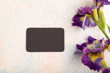 Beyaz çimento arka planda leylak zambaklı siyah kartvizit. Üst manzara, düzlük, kopyalama alanı, durağan hayat. Kahvaltı, sabah, bahar konsepti..