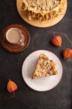 Geleneksel Litvanya keki shakotisi. Siyah beton arka planda bir fincan kahve. Üst görünüm, düz görünüm, yakın çekim.