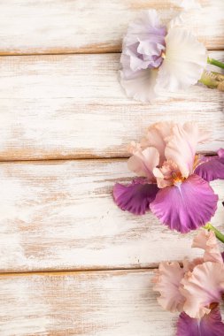 Beyaz ahşap arka planda leylak ve mor zambak çiçekleri. Üst manzara, düzlük, kopyalama alanı, durağan hayat. Kahvaltı, sabah, bahar konsepti..