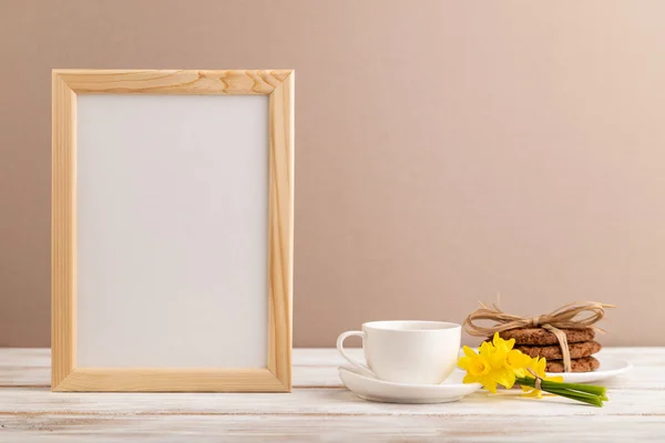 Houten Frame Met Havermoutkoekjes Gele Narcissen Koffiebeker Beige Pastelachtergrond Zijaanzicht Rechtenvrije Stockafbeeldingen