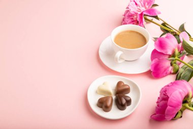Çikolatalı cioffee, pembe pastel arka planda pembe şakayık çiçekleri. Yan görüş, kopyalama alanı, durağan hayat. Kahvaltı, sabah, bahar konsepti..