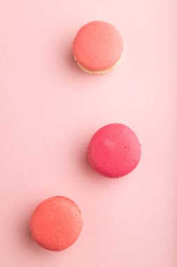 Pembe pastel arka planda mor ve pembe badem kurabiyeleri. Üst manzara, düz uzanma, durgun hayat. Kahvaltı, sabah, konsept..