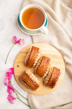 Geleneksel Ermeni tatlı gata, gri beton arka planda yeşil çay ve keten tekstil. Üst görünüm, düz görünüm, yakın çekim.