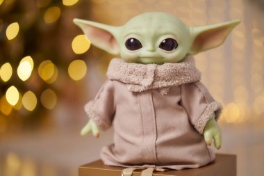 November, 2021: Baby Yoda, an action figures of Mandalorian with christmas decoration interior. Bokeh effect clipart